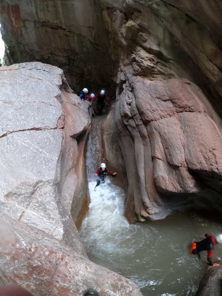 canyoniste qui fait un toboggan dans le canyon de la Roudoule à une heure de Nice et des gorges du Verdon