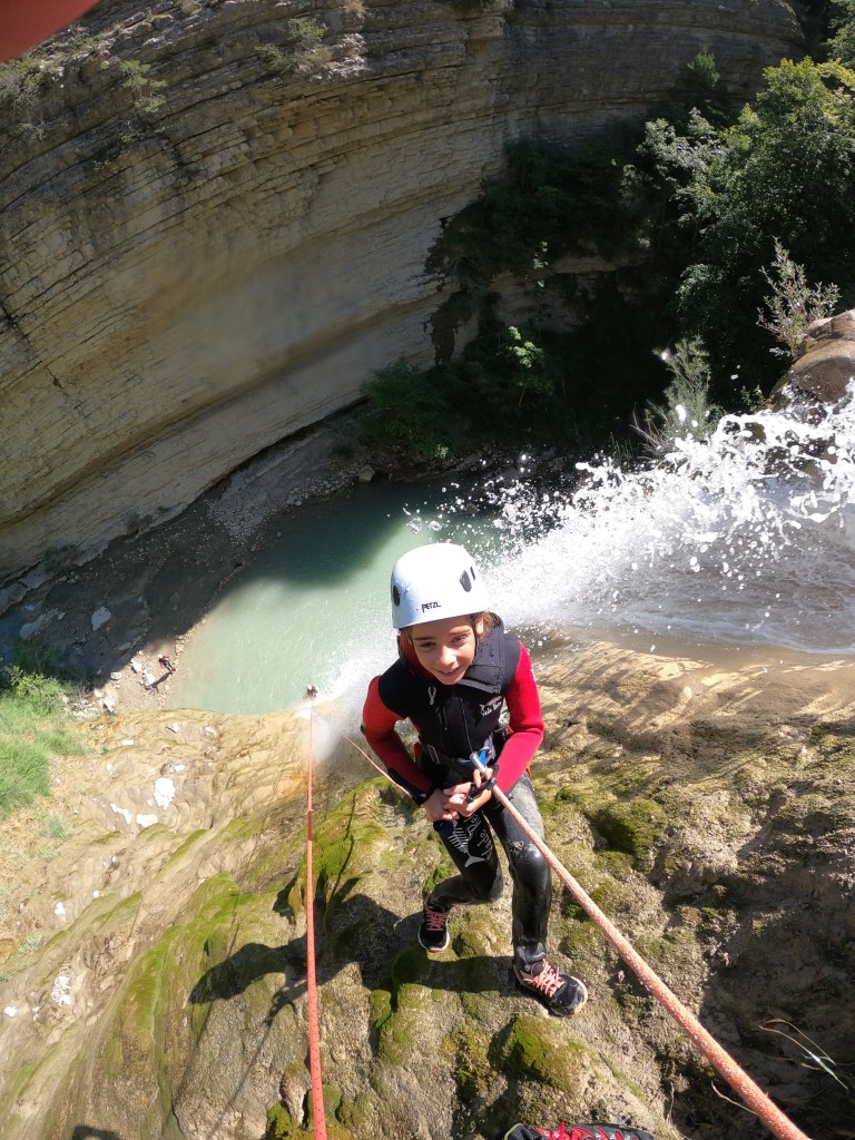 Une jeune participante descend le rappel de 35 mètres du canyoning de Chalvagne