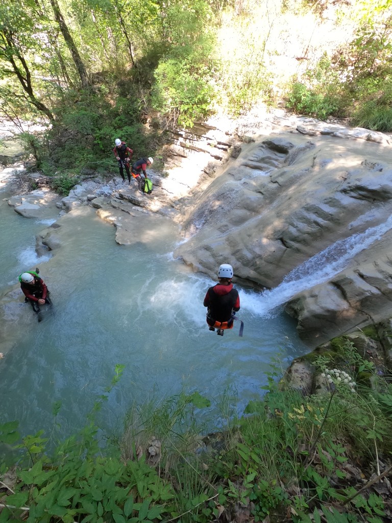 Un participant à une sortie canyoning saute dans une piscine naturelle à Entrevaux